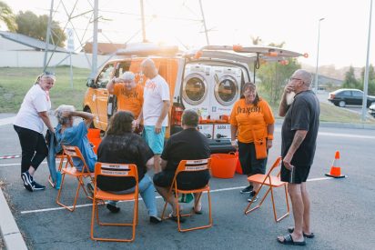 friends-and-volunteer-chat-in-front-of-laundry-van