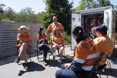 volunteers-chat-next-to-laundry-pod